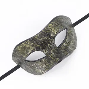Vue détaillée du masque vénitien vintage avec gaufrage floral doré et sangle noire.
