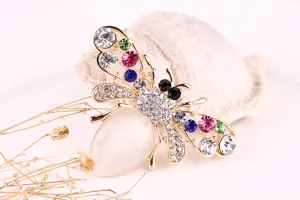 Detailed closeup of cute crystal bee brooch with cat-eye stone and rhinestones for women.