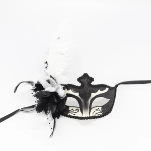 Vue détaillée du masque de bal masqué noir et blanc avec plumes et fleurs délicates.
