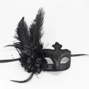 Gros plan de détail d'un masque de bal masqué noir avec plumes, fleurs et rubans élégants.