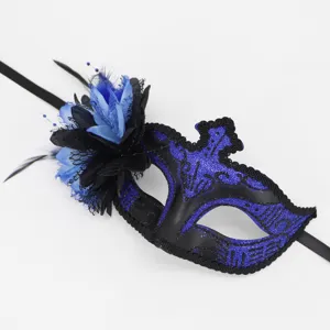 Detailopname van het masker met blauwe glitter, zwarte bloemen en delicate veren.