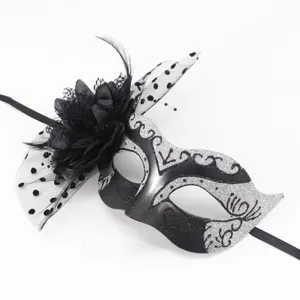 Detailed view of black and silver masquerade mask with lace, feathers, and ribbons for party.