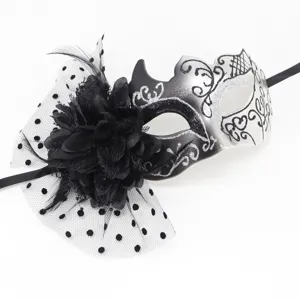 Detailed view of a black and silver masquerade mask with flower and dotted veil