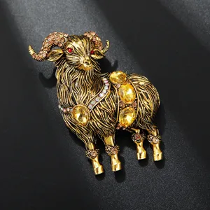 Close-up of a retro gold-tone alloy ram brooch, glittering rhinestones and yellow crystal details.