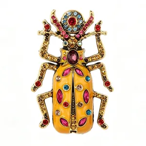 Detailed view of vintage gold alloy beetle brooch featuring yellow enamel and colorful rhinestones.