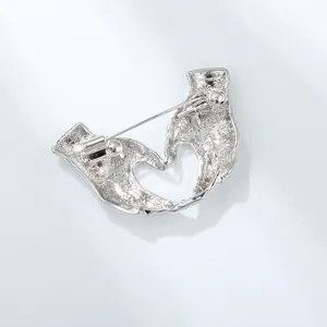 Detailed close-up of the silver alloy heart hands brooch back pin mechanism craftsmanship.