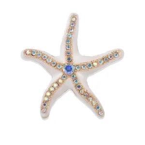Detailed close-up of a white enamel starfish brooch adorned with colorful rhinestones.