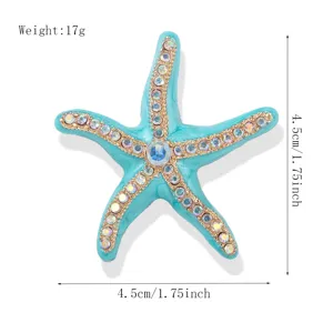 Turquoise enamel starfish brooch featuring sparkling rhinestones and gold metal trims.