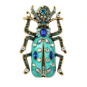 Detailed close-up of vintage gold alloy beetle brooch with green enamel and sparkling rhinestones.