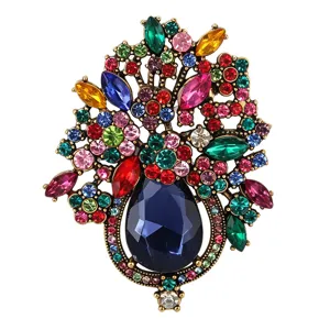 Detailed shot of vintage crystal flower basket brooch with colorful rhinestones and blue drop stone.