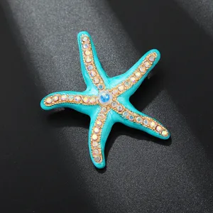 Close-up detail of a stunning turquoise enamel starfish brooch glittering with rhinestones.