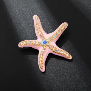 Exquisite enamel starfish brooch detail, featuring sparkling rhinestones and gold-tone metal trim.