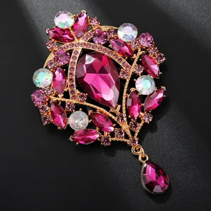 Detailansicht der luxuriösen Kristall Strass Brosche mit funkelnden rosa Steinen in Gold.