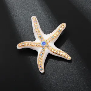 Exquisite white enamel starfish brooch adorned with sparkling rhinestones, perfect clothing accessory.