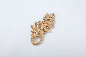 Detailed view of the gold-tone crystal rhinestone leaf brooch back with secure pin clasp.