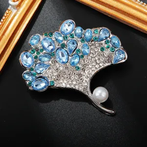 Elegante aquamarijn ginkgobladeren broche met sprankelende kristallen en parelaccent.