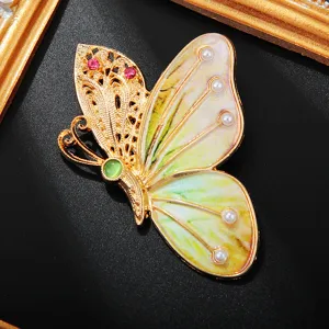 Gros plan détaillé de l'aile de broche papillon plaquée or exquise avec des cristaux.