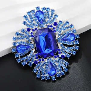 Close-up view of the royal blue crystal brooch with sparkling rhinestones and intricate silver base.
