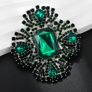 Close-up detail of luxurious vintage green crystal brooch showcasing brilliant emerald stones.