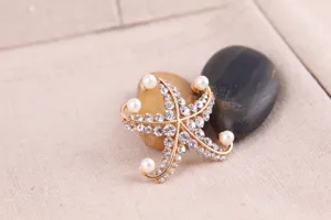 Detailierte Nahaufnahme einer goldenen Strass Perlen Seestern Brosche für elegante Damen.