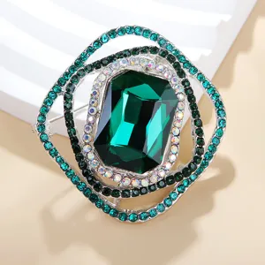 Exquisites Detail einer quadratischen grünen Strass-Brosche, elegante Schmucknadel Damen.