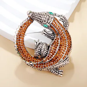 Detailaufnahme einer Vintage Strass Krokodil Brosche mit Bernstein Kristallen und grünen Augen.