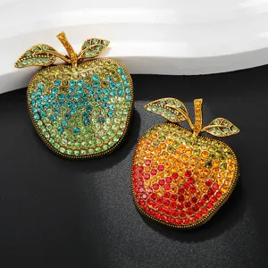Detailed close-up of crystal rhinestone apple brooch, sparkling gradient colors on gold tone.