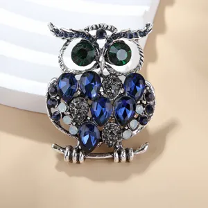 Vue detaillee de la broche hibou vintage ornee de strass bleus et verts scintillants.