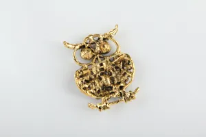 Vue rapprochée détaillée de l'arrière de la broche hibou dorée et son fermoir de sécurité.