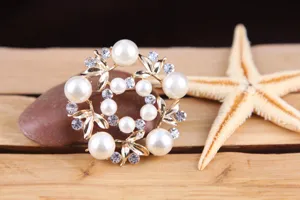 Detailaufnahme einer Perlen Strass Kranz Brosche mit funkelnden Kristallen und eleganten Perlen.