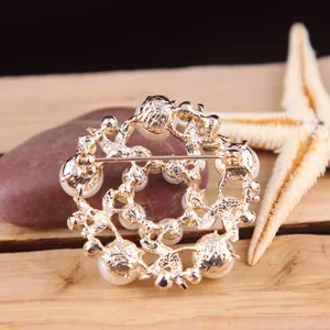 Elegante goldfarbene Kranzbroche mit Kunstperlen und filigranem Blumendesign für Damen.