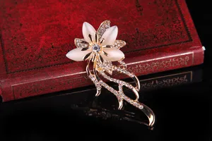 Elegante goldfarbene Blumenbrosche mit Katzenaugenstein-Blütenblättern und Strasssteinen.