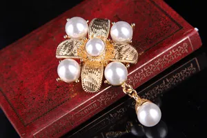 Nahaufnahme Detail der goldenen Perlen Kreuz Brosche mit Anhänger, elegantes Schmuckstück.