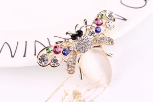 Close-up detail of a cute bee brooch featuring colorful rhinestones and white opal abdomen.