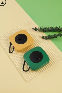 Detail view of portable folding shopping bag in yellow and green plastic storage cases.