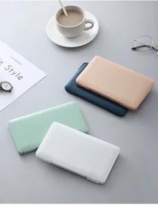 Nahaufnahme von pastellfarbenen Kunststoff-Aufbewahrungsboxen auf einem ordentlichen Schreibtisch.