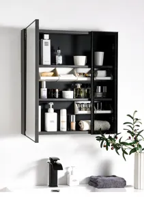 Detailed view of inclined storage boxes and layered shelving inside modern bathroom mirror cabinet.