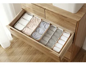 Plastic underwear and sock organizer detail view, showing segmented storage inside a wooden drawer.