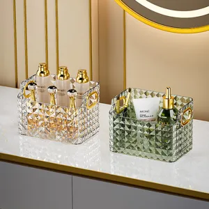 Boîte de rangement cosmétique transparente avec motif diamant et poignées dorées pour coiffeuse.