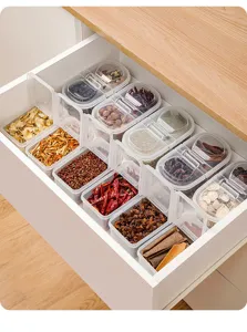 Détail de boîte de rangement d'épices en plastique transparent pour tiroir de cuisine.