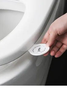 Toilet seat lifter sticker tool for sanitary hand-free bathroom lid opening convenience.