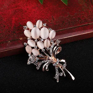 Gros plan de l'élégante broche bouquet avec pierres œil-de-chat roses et strass scintillants.