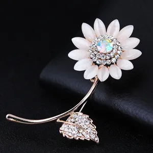 Dettaglio spilla girasole elegante, petali in pietra occhio di gatto bianca con strass luminosi.