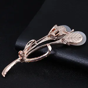 Detailed back view of rose gold tulip flower brooch with white cat eye stone for garment accessory.