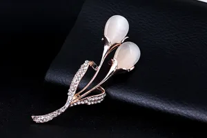 Close-up detail of the elegant rose gold tulip brooch with cat's eye stone and rhinestones.