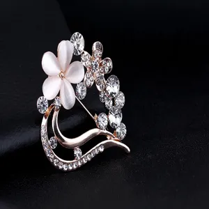 Detaillierte Nahaufnahme einer eleganten Katzenaugenstein und Strass Pflaumenblüten Brosche.