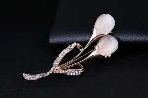 Elegant rose gold tulip brooch featuring white cat eye stone and sparkling rhinestones for apparel.