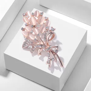 Élégante broche bouquet de fleurs or rose avec pierre œil de chat rose et strass étincelants.