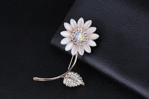 Primo piano dettagliato di una spilla girasole scintillante con petali in pietra di gatto.