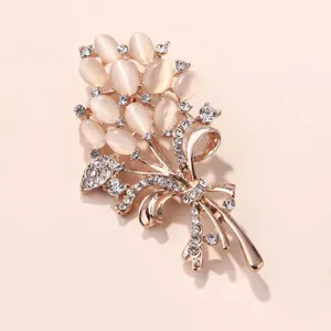 Exquise broche bouquet dorée avec pierres d'œil de chat et strass en cristal étincelants.